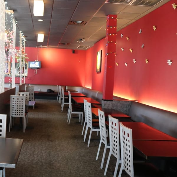 Chaba Thai Restaurant's dining area with red walls, white chairs, and dark tables.