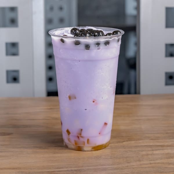 Chaba Thai Restaurant's purple bubble tea with dark boba pearls and fruit jelly on a wooden table.